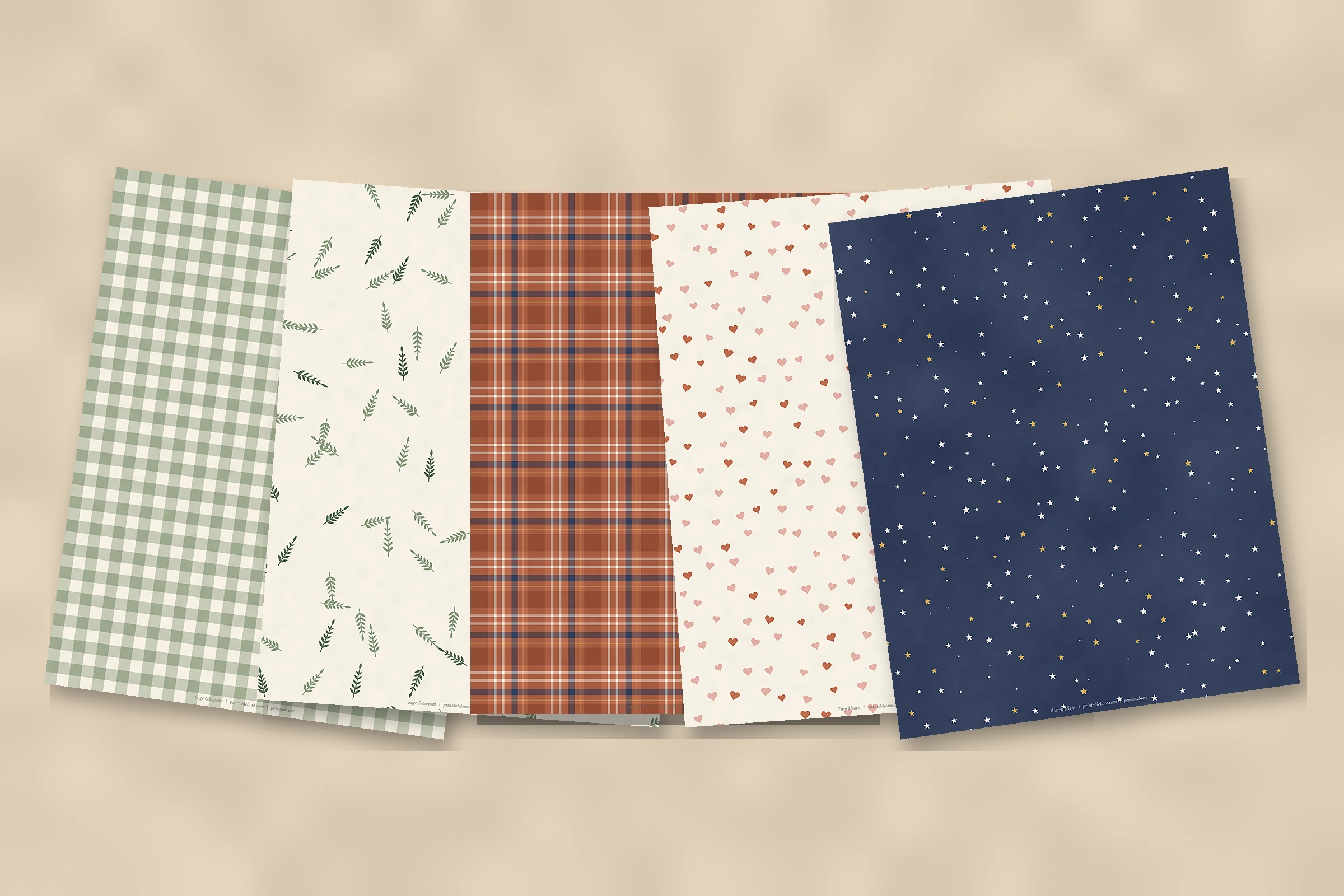 Five free printable scrapbook papers laid out on a table: gingham, botanical, plaid, hearts and stars